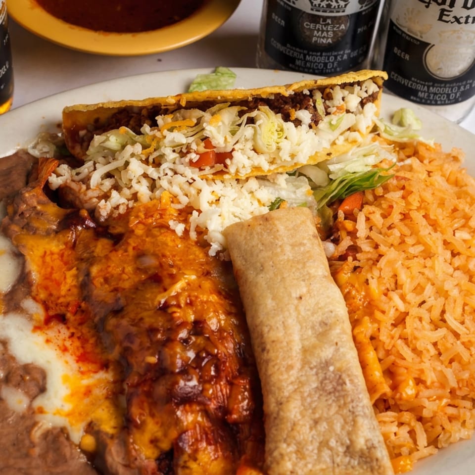 Mexican combo plate with refried beans, orange rice, enchiladas, a crispy taco, and a rolled tortilla beside Corona beers.