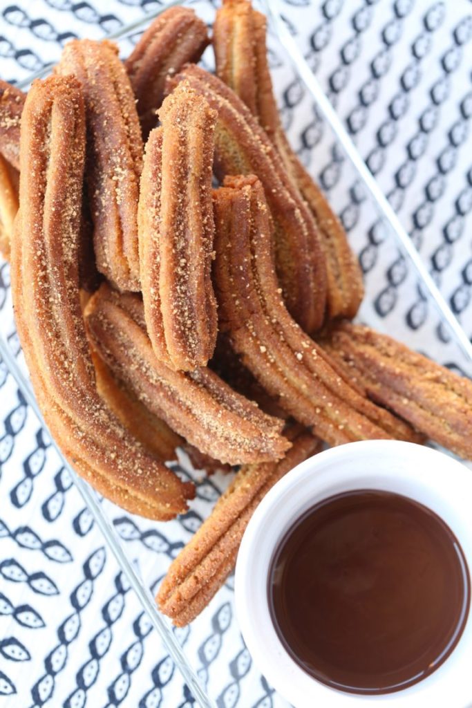 churros and melted chocolate in a cup