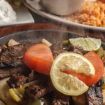 Beef Fajita lemon slice tomatoes and onions rice avocado