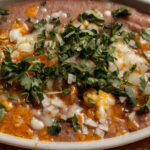 refried beens with beef cheese and parsley on top