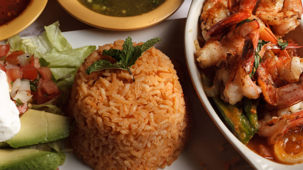 rice avocado spicy shrimp mexican style in a plate, pico de gallo