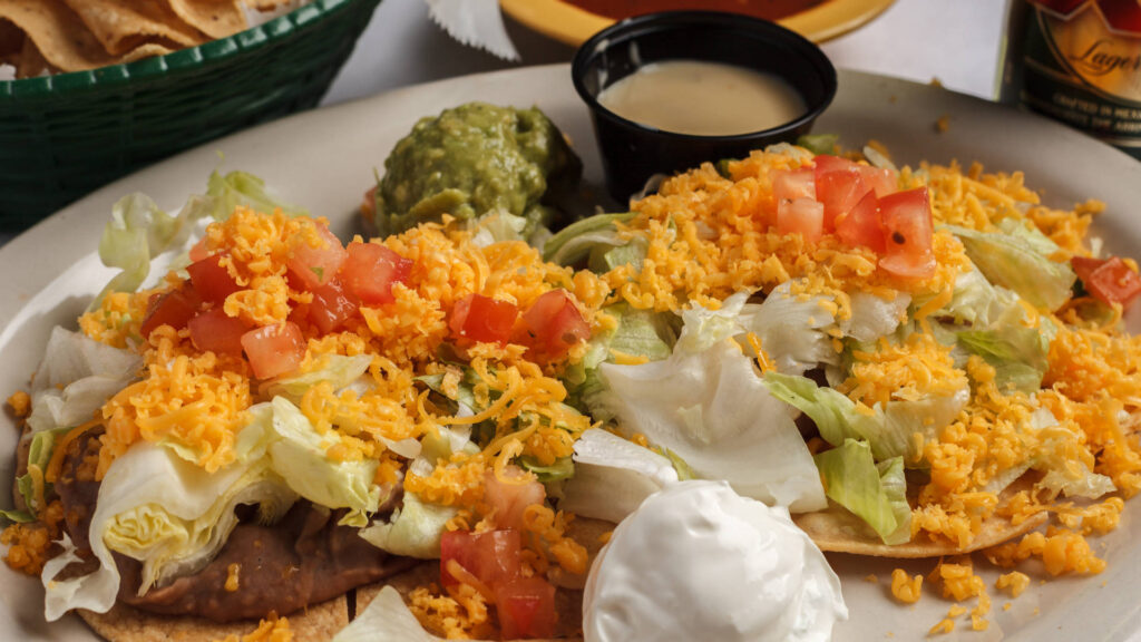 two chalupas lettuce tomatoes pico de gallo cup with sauce cheese guacamole sour cream