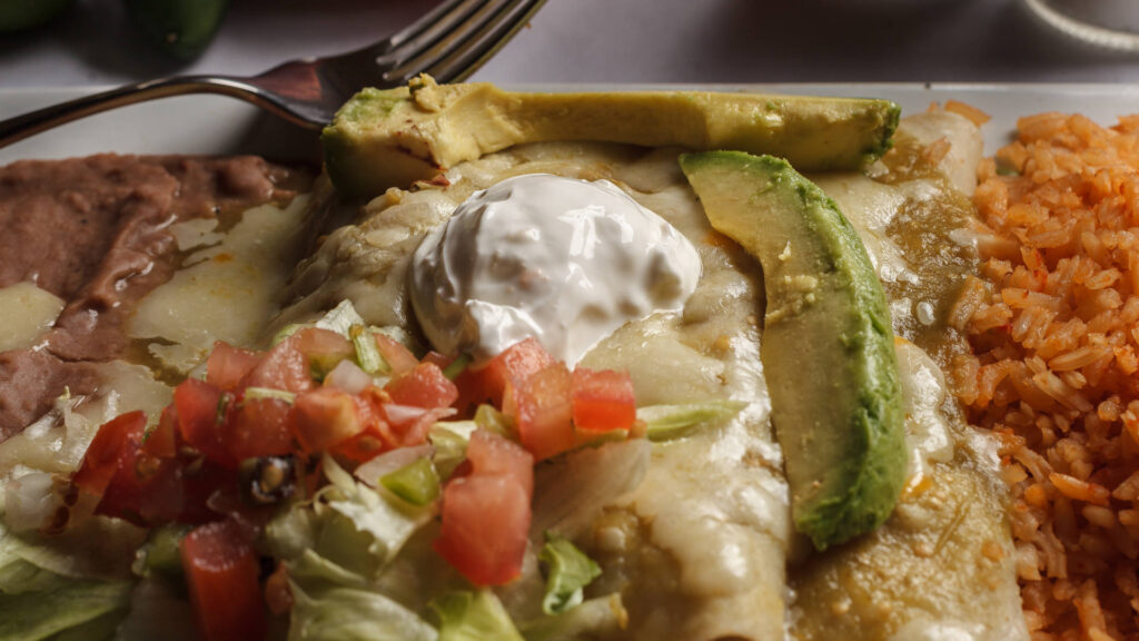 avocado rice enchilada with sour cream on top pico de gallo fried rice and melted cheese