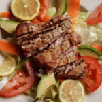 grilled tuna sliced lemons Iceberg lettuce sliced tomato avocados and shredded carrots