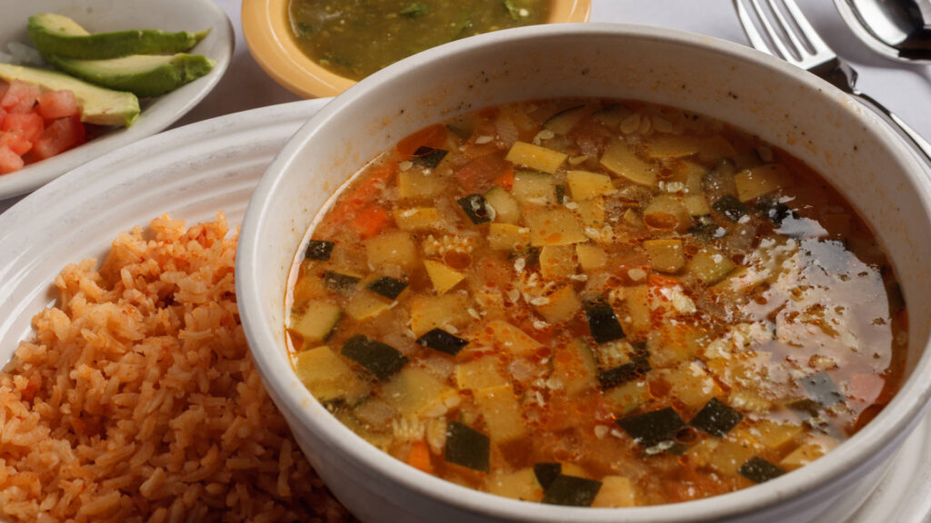 chicken onions tomato cilantro avocados broth and rice on the side