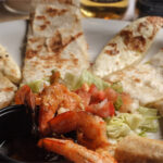 quesadilla slides 4 shrimps on the side of a cup with sauce 1 flauta